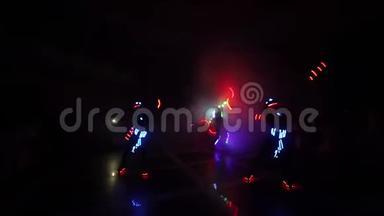 激光LED显示。 艺术家在黑暗的房间里展示舞蹈和激光表演。 衣服散发着冰和激光的光芒。 夜晚